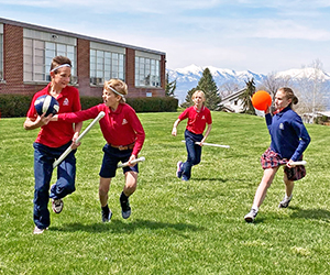 Action shot of students playing the game of "Quidditch."