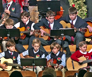 Students play guitars during a holday program.
