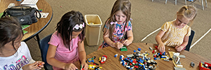 Preschool students build with LEGOs.